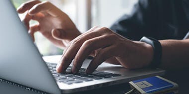 Man typing with GO NFC PAD Reader on the side