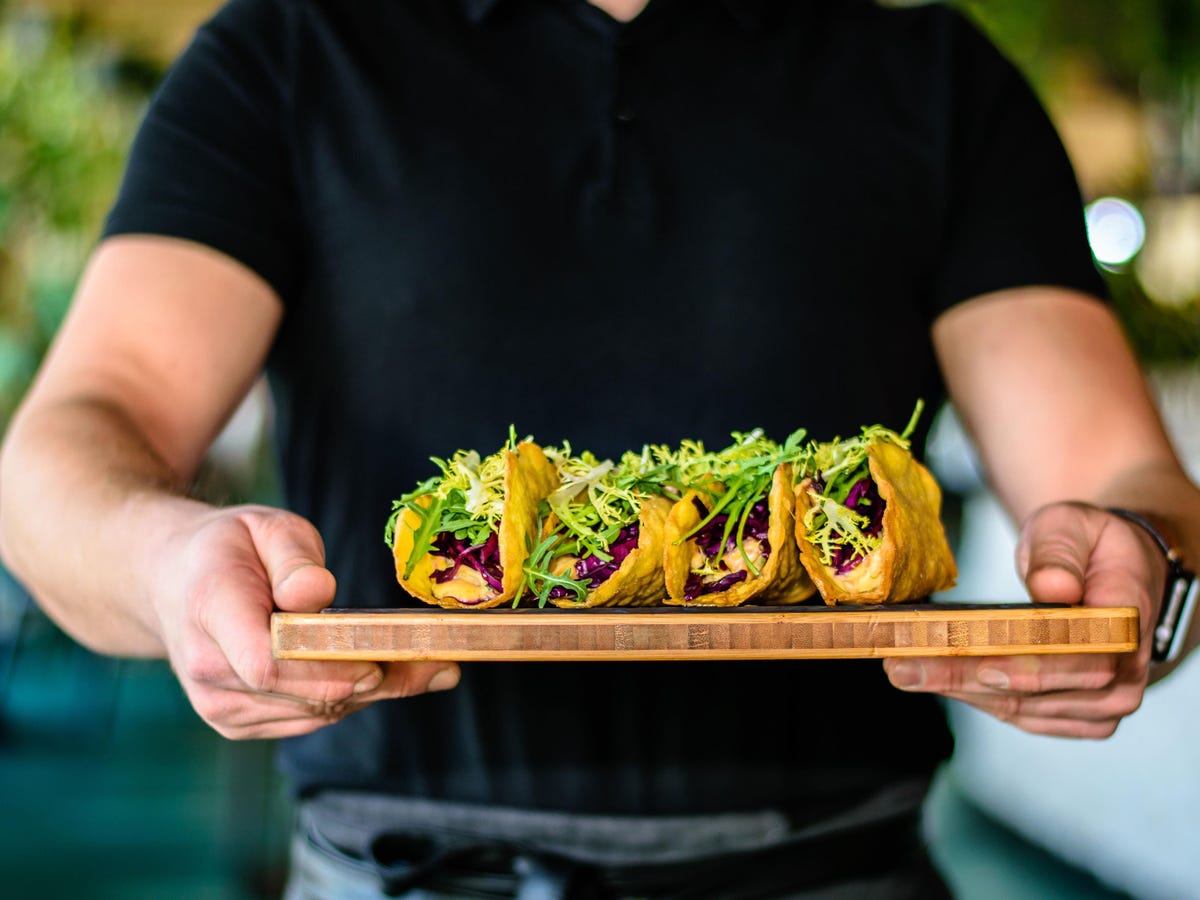 Waiter holding a dish of tacos