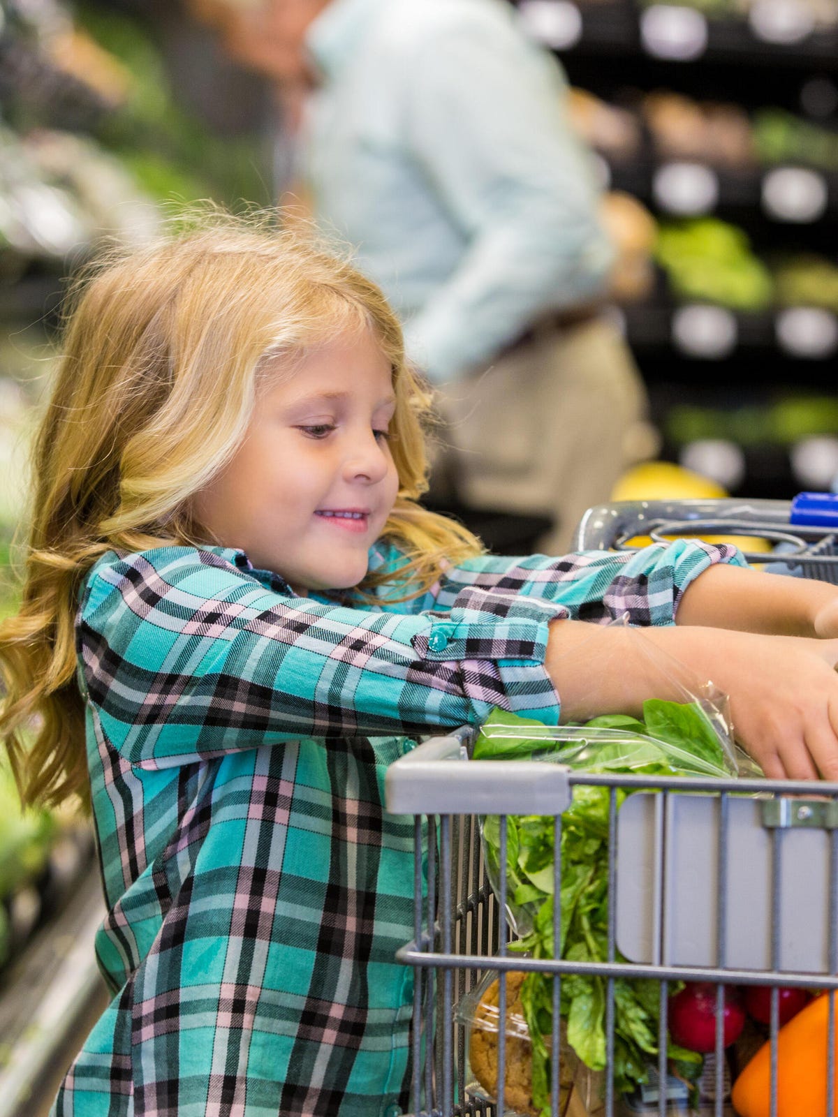 Une petite fille aide à faire les courses dans une épicerie