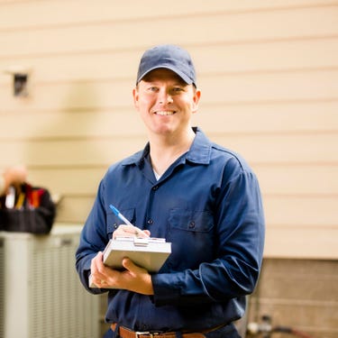 Smiling man holding a checklist with a pen