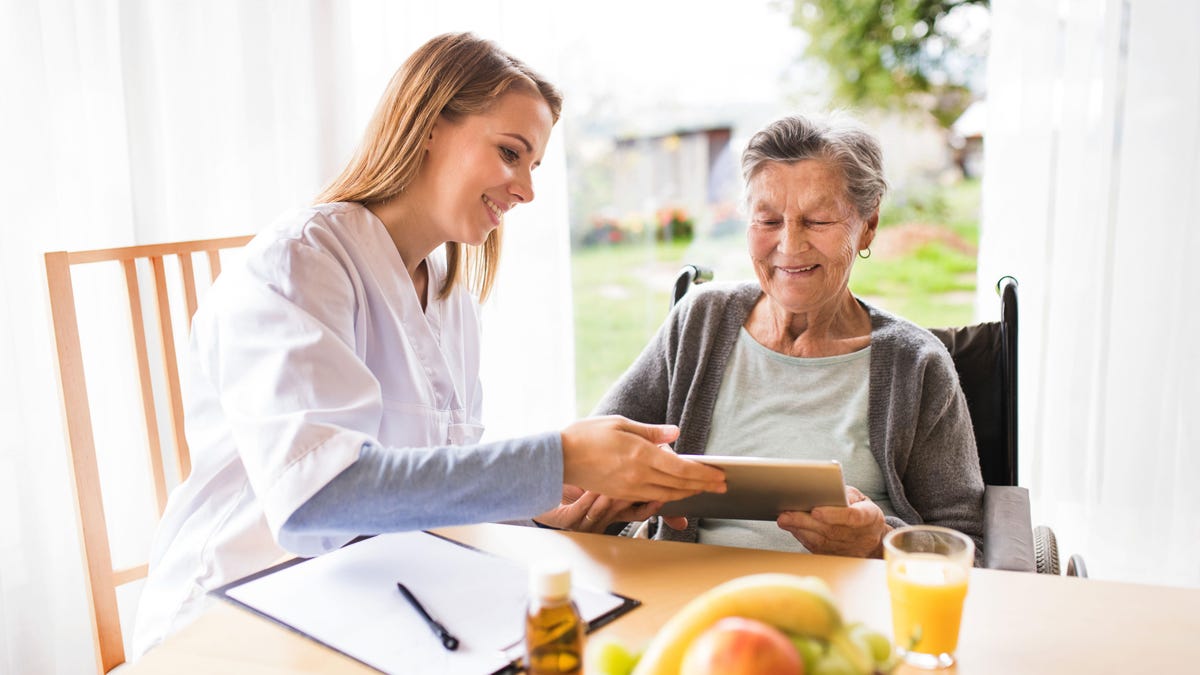 Personnel infirmier avec un patient âgé et une tablette Personnel infirmier avec un patient âgé et une tablette