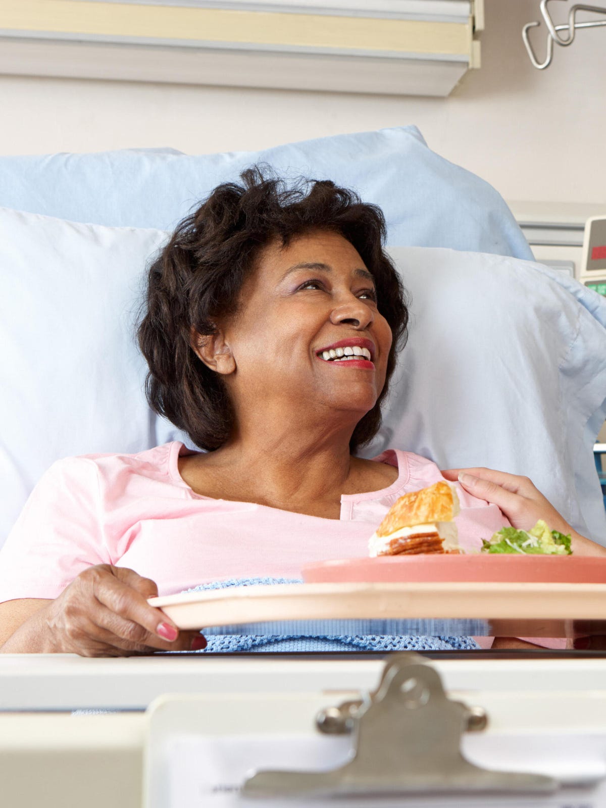 Nurse serving patient meal in bed Nurse serving patient meal in bed