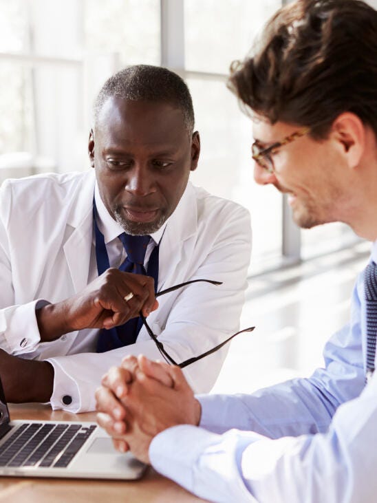 Deux médecins parlant devant un ordinateur portable