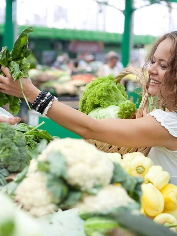 Close up of a smiling woman shopping vegetables