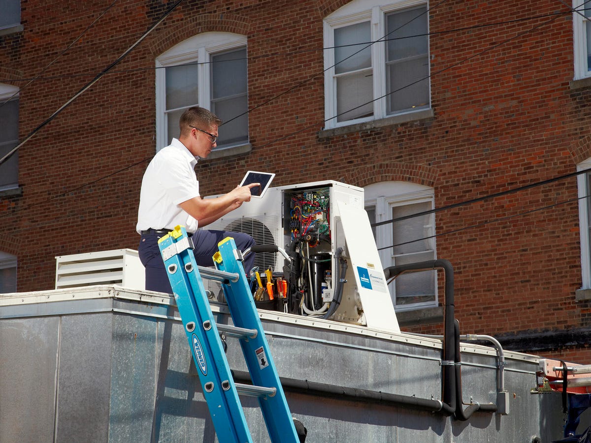 technician repairing outdoor condensing unit