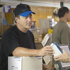 Employee at the checkout counter handling purchased item