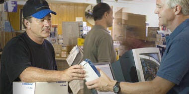 Employee at the checkout counter handling purchased item