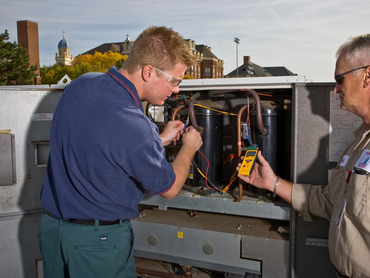 Two engineers checking scroll compressors