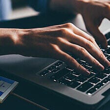 Man typing with GO NFC pad reader on the side