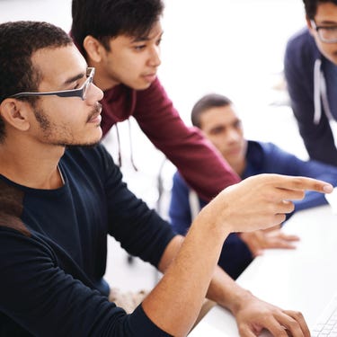 Employees having discussion in front of the computer monitor