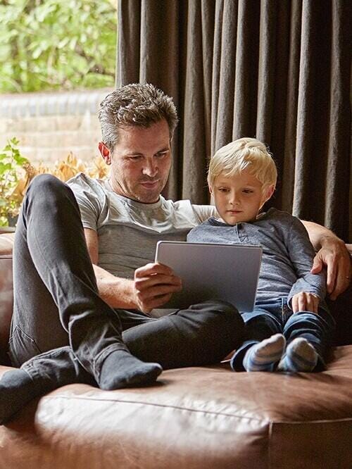 Father and son lounging with tablet