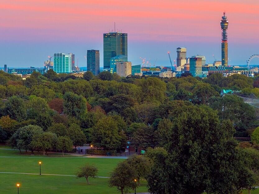 Green landscape with city skyline backdrop