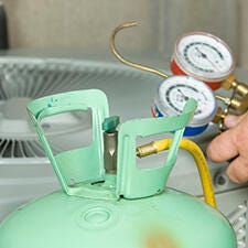 Close up of a refrigerant tank and pressure gauge