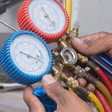 Technician holding dual pressure gauge