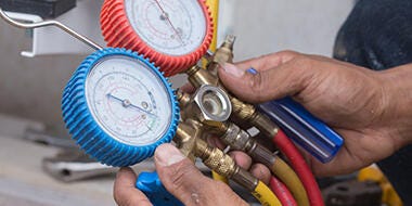 Technician holding dual pressure gauge