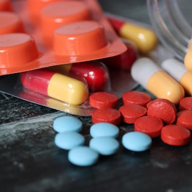 Pills and capsules on dark table