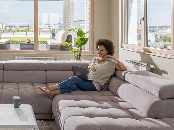 Woman with laptop lounging in the living room