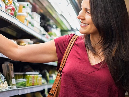 Woman shopping along chiller aisle