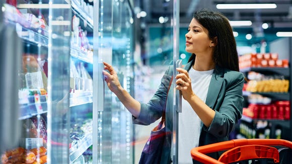 smiling-woman-buying-groceries-at-refrigerated-section-in-supermarket smiling-woman-buying-groceries-at-refrigerated-section-in-supermarket
