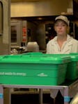 Supermarket employee holding a food waste to energy bin