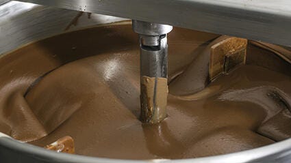 Industrial machine mixing chocolate