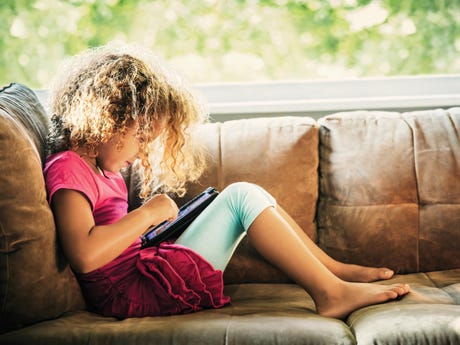 Girl reads an e-reader on couch