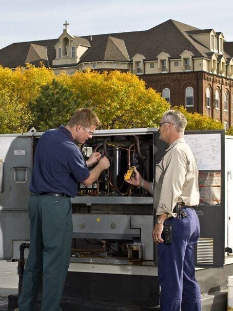 Two engineers checking HVAC unit