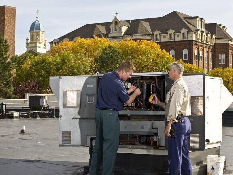 Two engineers checking HVAC unit