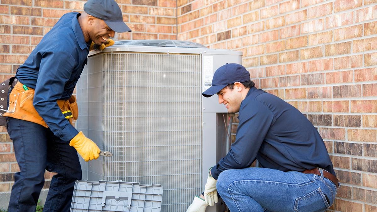 Contractors setting up a new air conditioner